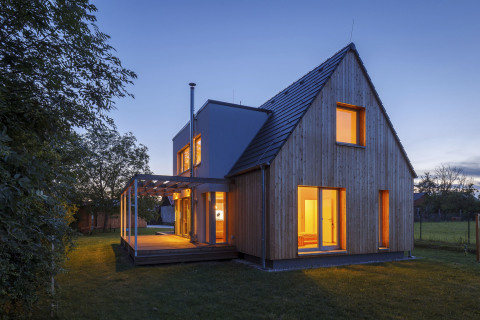 K domu se z jižní strany připojuje dřevěná paluba s pergolou ze subtilních lepených dřevěných hranolů