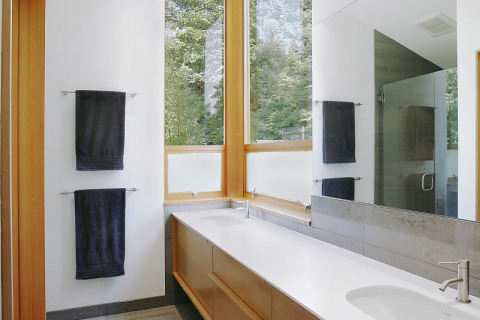 Po vzoru ostatních místností v domě i design koupelny kombinuje dřevěné prvky a bílou barvu
