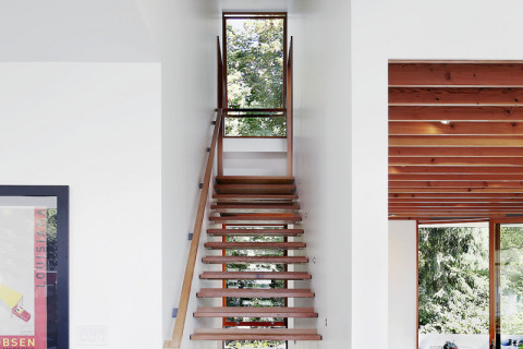 Jednoduché a prostorově úsporné schodiště z dřevěných desek spojuje kuchyni a druhé patro