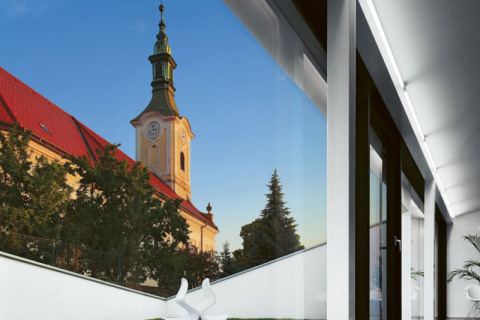 Přímý výhled z obývacího pokoje na věž kostela sv. Františka Xaverského byl jedním z hlavních motivů, které vedly k architektonickému řešení domu. Podařilo se tak dosáhnout propojení lidského příbytku s příbytkem duchovním