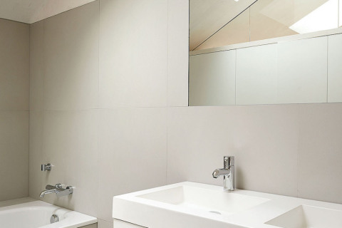 V koupelně architekt použil velkoformátový keramický obklad, jeho odstín se blíží barvě světlého dřeva