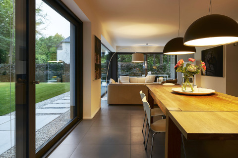 Protáhlý společný obývací prostor vyplňuje většinu dispozice přízemí a je plně orientován do klidové části zahrady