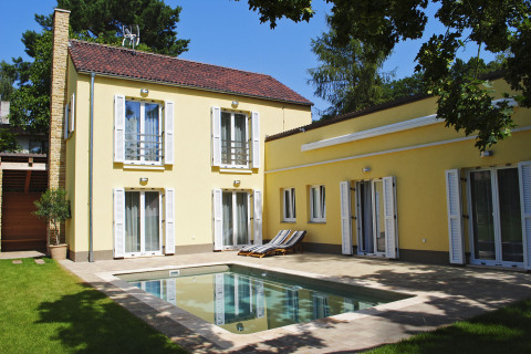 Velkou část terasy zaplňuje vyhřívaný keramický bazén, jenž spolu s bílými okenicemi zvýrazňuje středomořský charakter domu