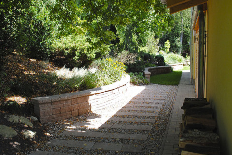 Mezi zadní stranou domu a zahradou je použita zajímavá kombinace betonové dlažby a kačírku