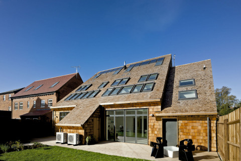 Pohled východní. Šikmá střecha přecházející přes dvě podlaží je základnou pro dvě řady střešních oken a solární kolektory